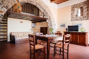 a dining room with a table and chairs and a couch at Tenuta La Selva Casa Pendio in Casal Velino