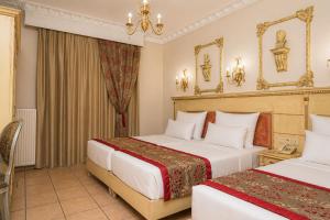 a hotel room with two beds and a chandelier at Parthenon Art Hotel-Seaside Collection in Olympic Beach +53 photos