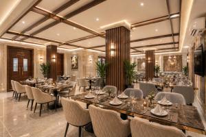 a restaurant with tables and chairs in a room at Hotel Eden Suites Delhi Airport in New Delhi
