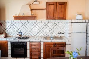 a kitchen with a sink and a stove top oven at Tenuta La Selva Casa Pendio in Casal Velino +1 photo