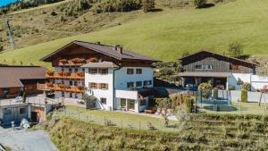 a large white house on a hill with a yard at Pension Hedegghof in Grossarl