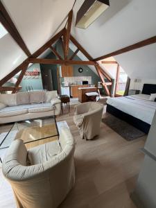 a living room with a bed and couches in a room at Ferme de Montecouvez in Crèvecoeur-sur-lʼEscaut