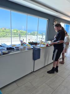 a woman standing at a counter preparing food at Beachway Hotel in Side
