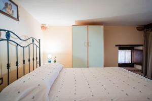 a bedroom with a bed with a white bedspread at Tenuta La Selva Casa Pendio in Casal Velino