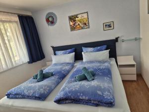 a bedroom with two twin beds with blue pillows at FeWo Aquileia Scuol, Gratisparken, Terrasse, Wifi, flexible Zimmerwahl, Familien in Scuol