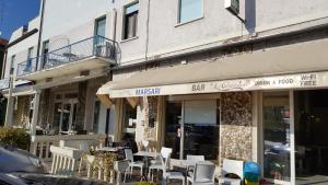 a woman sitting at a table outside of a restaurant at Albergo Marsari in Peschiera del Garda