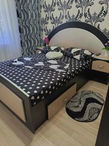 a bed with a black and white comforter in a bedroom at Apartament Arys 2 in Neptun