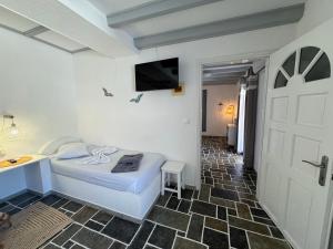 a bedroom with a bed and a sink and a door at Ergina Studios in Ios Chora
