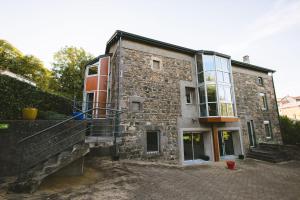 an old stone building with a staircase in front of it at L'Oustal des Dômes in Orcines
