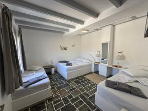 a room with two beds and a mirror at Ergina Studios in Ios Chora