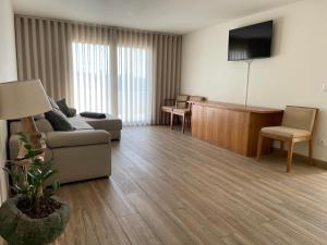 a living room with a couch and a desk and a television at Casa das Cucas in Pombal