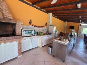 a large kitchen with white cabinets and a microwave at Studio Filippos in Possidi