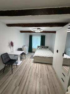 a bedroom with a bed and a desk and a table at Cozy Forest House in Jonkowo