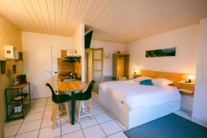 a bedroom with a bed and a table and a desk at L'Oustal des Dômes in Orcines