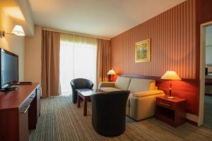 a hotel room with a couch and a television at Hotel Bellevue - Metropol Lake Resort in Ohrid