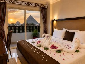 a hotel room with two swans on a bed with flowers at Flower Pyramids Inn in Cairo