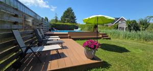 a row of benches with an umbrella next to a pool at De Bascule in Sexbierum