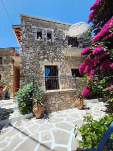 a stone house with potted plants in front of it at Epavli Veneti in Parga