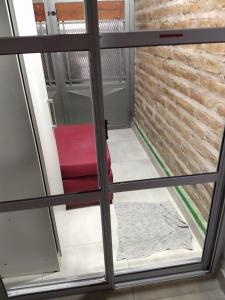 a red chair sitting in front of a door at Departamento familiar in General Roca