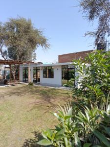 a white house with windows and a yard at Casa Rústica Diaz in Ica