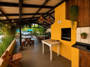 a patio with a table and some tables and chairs at Solar das Andorinhas Pousada in Itapoa