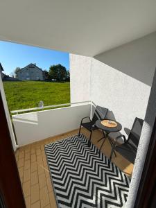 a balcony with two chairs and a table on a rug at Apartment Eppingen in Eppingen