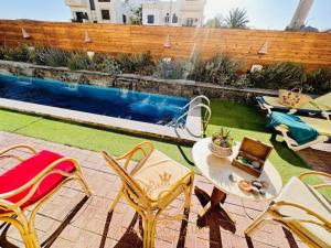 a patio with chairs and a table and a swimming pool at Casa Do Cairo-Sharm Alsheikh in Sharm El Sheikh