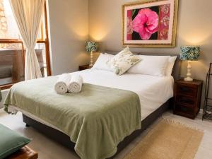 a bedroom with a bed with towels on it at Tanzanite in Paternoster