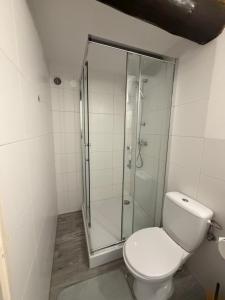 a bathroom with a toilet and a glass shower at Cozy Forest House in Jonkowo