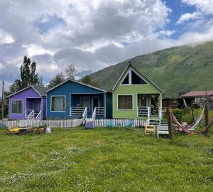 a colorful house with a mountain in the background at Cottage kazbegi sioni in Kazbegi