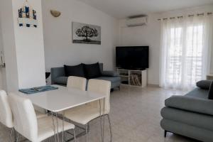 a living room with a white table and a tv at Apartments Verica in Pag