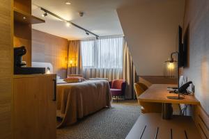 a hotel room with a bed and a window at Van der Valk Hotel Emmen in Nieuw-Amsterdam