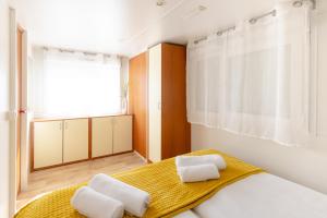 a bedroom with a bed with two towels on it at Bol Cutie in Murvica
