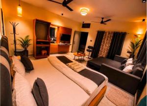 a bedroom with a large bed and a living room at The Peach Boho in Mount Ābu