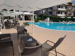 a patio with tables and chairs and a swimming pool at La Casa Serena in Scalea