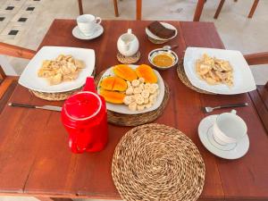 a wooden table with plates of food on it at SIlvas Surf Home in Weligama