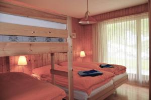 a bedroom with a bunk bed with red sheets at Immeuble Les Mélèzes in Les Collons +95 photos