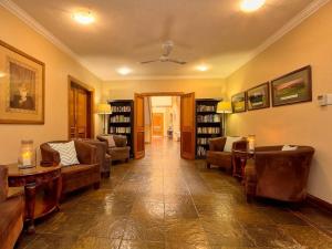 a living room with couches and tables and bookshelves at Centurion Golf Suites Boca Walk in Centurion +8 photos