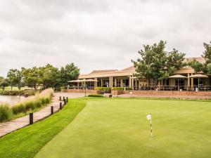 a golf course with a putting green in front of a building at Centurion Golf Suites Boca Walk in Centurion