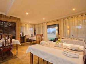 a dining room with white tables and chairs and a kitchen at Centurion Golf Suites Boca Walk in Centurion