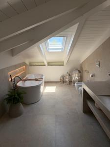 a bathroom with two sinks and a tub and a skylight at Villa Forni in Cesenatico +56 photos