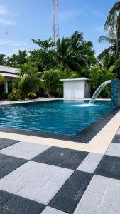 a swimming pool with a fountain in a resort at Coconut Leaf Shadow Guest in Nilaveli +24 photos