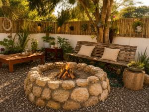 a fire pit in a yard with a bench at Tanzanite in Paternoster