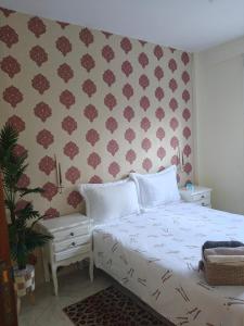 a bedroom with a white bed and a wall at Slow Life Bouznika in Bouznika