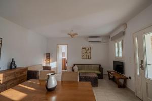 a living room with a vase sitting on a table at Kriolithos Houses in Parikia