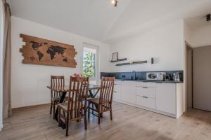 a kitchen with a table and chairs in a room at TOPOLIŲ Apartamentai in Palanga
