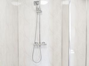 a shower with a shower head in a bathroom at Christine Cottage in Flamborough