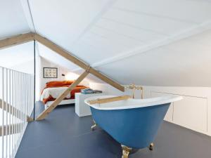 a bathroom with a blue bathtub and a bed at Sparrows Nest - Uk50109 in Longham