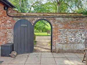 an entrance to a brick wall with a wooden door at Sparrows Nest - Uk50109 in Longham