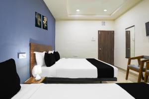 a hotel room with two beds and a chair at Townhouse RIO in Hyderabad